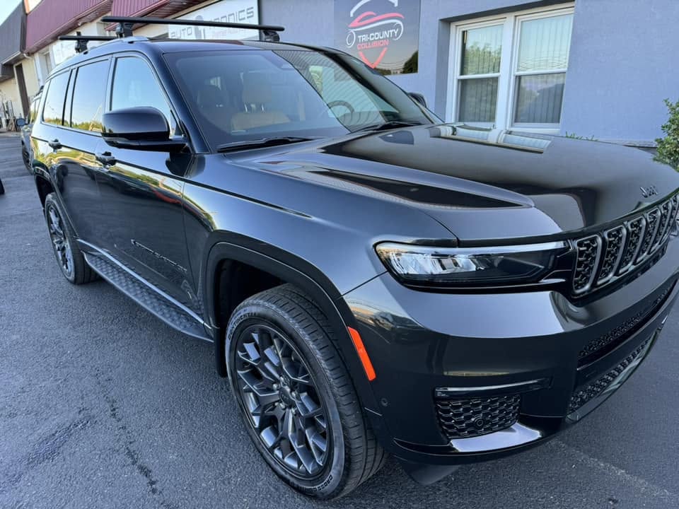 The same Jeep Grand Cherokee L finished, parked outside the Tri County Collision Center building.