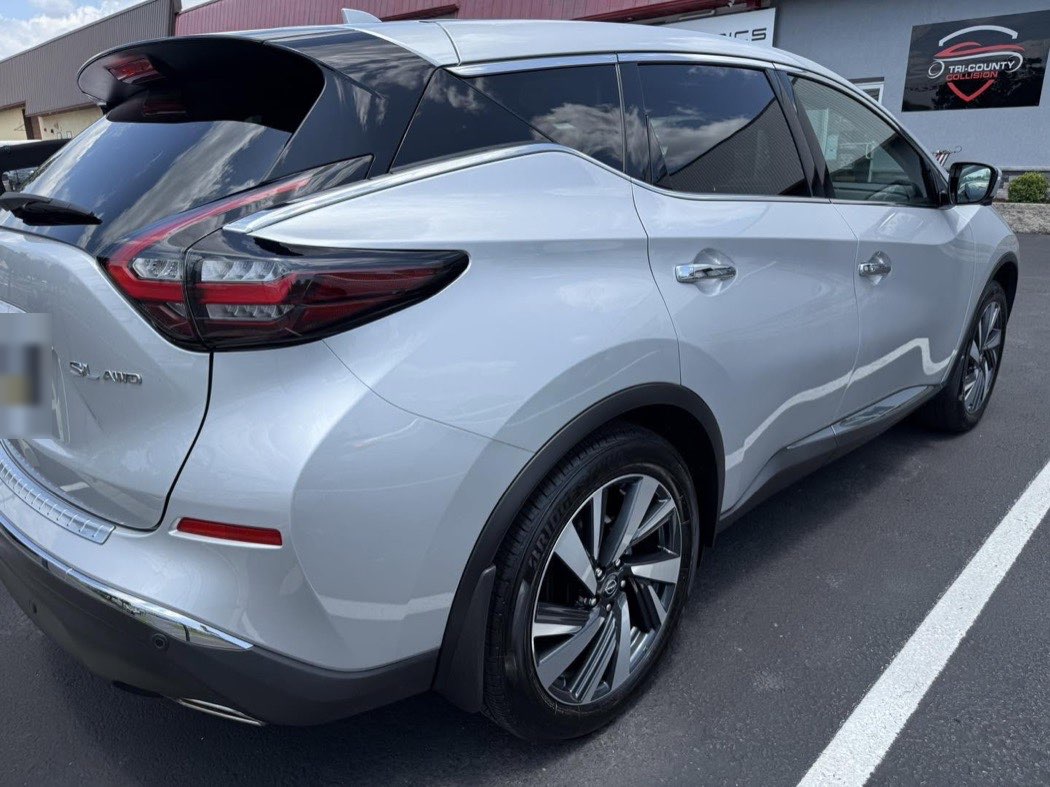 The same Nissan Murano after repair, rear door and quarter panel smooth again, parked at the shop.